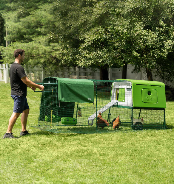 Man flyttar Eglu Cube portabelt hönshus med hjul och handtag